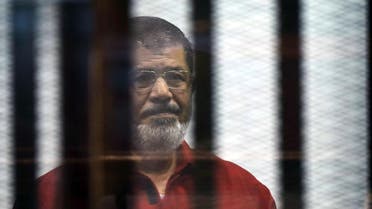 Egypt's ousted Islamist president Mohamed Morsi, wearing a red uniform, stands behind the bars during his trial in Cairo on June 21, 2015. AFP 