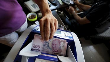 A money changer uses a machine to count Turkish liras in the border city of Hatay, Turkey in this September 17, 2013 file photo. Reuters