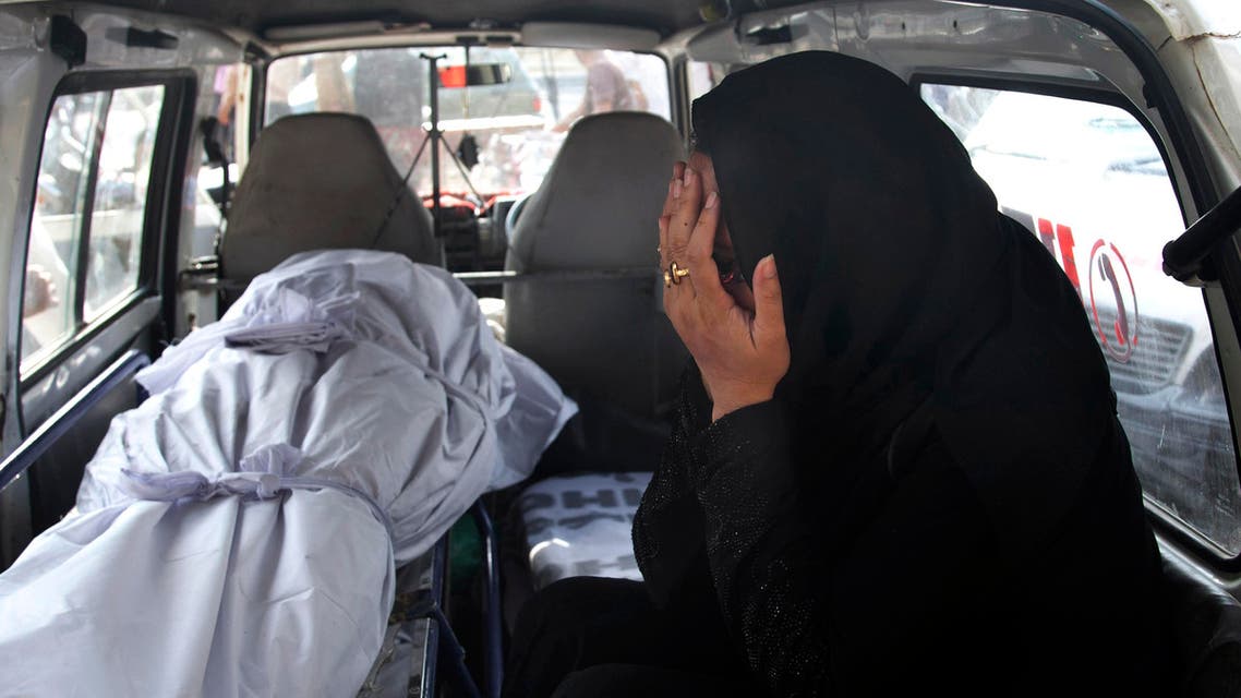 A Pakistani woman mourns as she sits beside the lifeless body of her relative who died from a heatstroke, inside an ambulance at a morgue of a charity group, in Karachi, Pakistan, Monday, June 22, 2015. (AP)