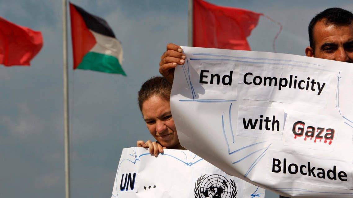 Palestinian and foreign activists hold placards in front of Palestinian and Turkish flags during a rally to show their support for two boats carrying 27 civilians from various countries attempting to reach the Gaza Strip, in the sea port of Gaza City Friday, Nov. 4, 2011. AP