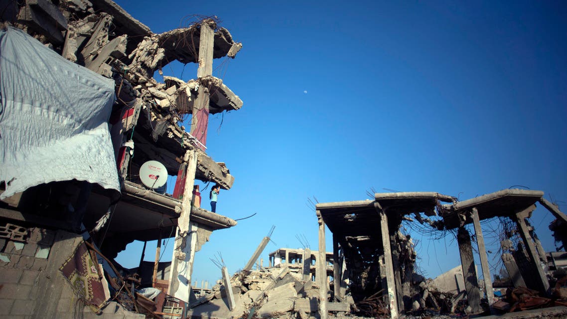 A Palestinian girl stands on the edge of a destroyed house where her family returned to live in the Shijaiyah neighborhood of Gaza City, Monday. (File Photo: AP)