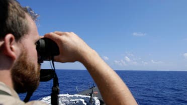Gregori Nills, a crew member of the command bridge, looks through binocular aboard of the Belgian Navy Vessel Godetia during a migrants search and rescue mission in the mediterranean sea off the Sicilian coasts, Italy, Saturday, June 20, 2015. AP