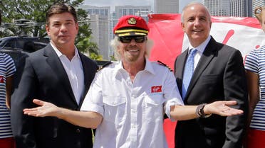 Richard Branson, founder of the Virgin Group, center, Virgin Cruises CEO Tom McAlpin, left, and Miami-Dade County Mayor Carlos Gimenez, right, pose for photos, Tuesday, June 23, 2015, at Perez Art Museum in Miami. Branson and McAlpin announced that Virgin Cruises will set sail from PortMiami in 2020.
