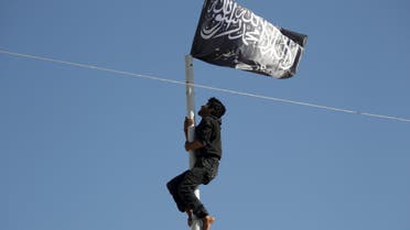 A member of al Qaeda's Nusra Front climbs a pole where a Nusra flag was raised at a central square in the northwestern city of Ariha, after a coalition of insurgent groups seized the area in Idlib province May 29, 2015. Reuters