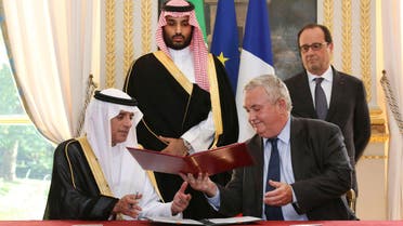 Eurocopter Senior Vice President for Sales and Customer Relations Olivier Lambert (R) exchanges documents with Saudi Foreign Minister Adel al-Jubeir, after signing an agreement for the sale of 23 helicopters to Saudi Arabia, in front of French President Francois Hollande (Top R) and Saudi Arabia's Deputy Crown Prince Mohammed bin Salman at the Elysee Palace in Paris, France, June 24, 2015. Reuters