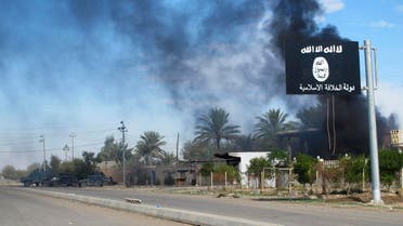 Smoke raises behind an Islamic State flag after Iraqi security forces and Shiite fighters took control of Saadiya in Diyala province from Islamist State militants, November 24, 2014. 