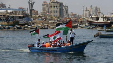 Palestinians hold flags as they ride a boat during a rally marking the 5th anniversary of the Mavi Marmara Gaza flotilla incident