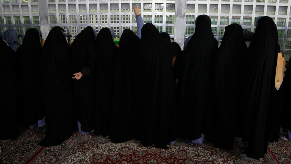 Iranian school girls pray, as they touch bars of the grave of the late revolutionary founder Ayatollah Khomeini (File Photo: AP)
