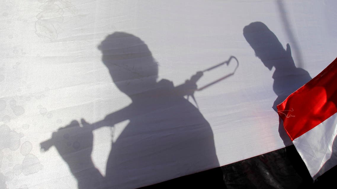The shadow of Shiite rebels, known as Houthis, are cast on a large representation of the Yemeni flag as they attend a demonstration against an arms embargo imposed by the U.N. Security Council on Houthi leaders, in Sanaa, Yemen, Thursday, April 16, 2015. Al-Qaida’s branch in Yemen seized Thursday control of a major airport and sea port and oil terminal in southern Yemen, consolidating their hold of the country’s largest province amid wider chaos that is pitting Shiite rebels against forces loyal to the country’s exiled president and a Saudi-led air campaign.(AP Photo/Hani Mohammed)