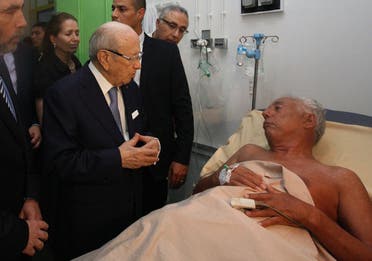  A handout picture release by the Tunisian Presidency on its Facebook page on June 26, 2015, shows Tunisia's President Beji Caid Essebsi (C) visiting a survivor of the mass shooting in the resort town of Sousse, a popular tourist destination 140 kilometres (90 miles) south of the Tunisian capital, at the Sahloul hospital in Sousse. AFP