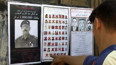 An Iraqi man looks at wanted posters distributed by U.S. forces in Ramadi, Iraq, Monday, March 21, 2005. (AP)