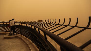 A couple observe a sandstorm that shrouds the capital city from an observation deck of the Cairo Tower in Zamalek, Cairo, Egypt, Saturday, June 27, 2015. (AP)