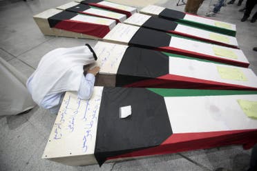 A man reacts next to coffins of victims of Friday's bombing at the Imam Sadeq mosque in Kuwait City, at the international airport in Najaf. (Reuters)