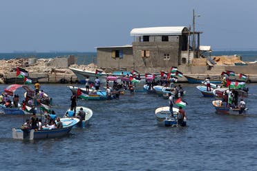 Palestinian protesters sail into the Mediterranean sea while waving their national flags during a protest calling to free the Marianne vessel one of four boats sailing to break the blockade on Gaza strip, at the fishermen port in Gaza City, in the northern Gaza Strip, Monday, June 29, 2015. (AP)