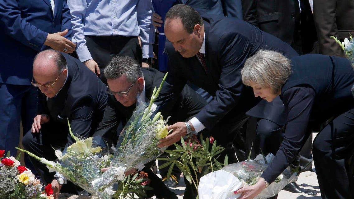 From right to left British Home Secretary Theresa May, Tunisian Interior Minister Mohamed Najem Gharsalli, , German Interior Minister Thomas de Maiziere and French Interior Minister Bernard Cazeneuve lay flowers on the beach in front of the Imperial Marhaba hotel in the Mediterranean resort of Sousse for the tribute in Sousse, Tunisa, Monday, June 29, 2015. AP