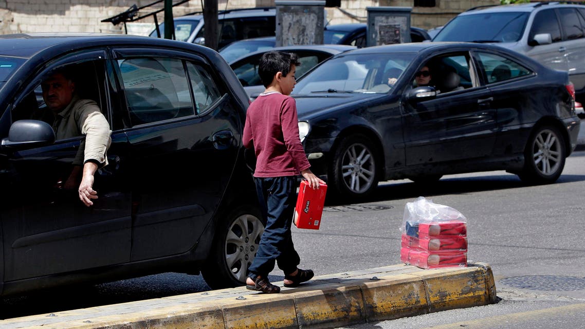 A Syrian street vendor, who fled his home in Syria, sells tissues in Beirut, Lebanon, Wednesday, April 15, 2015