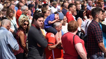 Members of the public observe a minute's silence for the victims of the Tunisia attacks outside Walsall football club in central England, on July 3, 2015. AFP