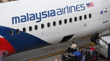 A Malaysia Airlines ground staff member unloads luggage from a plane at Kuala Lumpur International Airport in Sepang, Malaysia Monday, June 1, 2015. The new CEO of Malaysia Airlines said the ailing carrier could break even by 2018 after cutting staff, selling surplus aircraft and refurbishing its international fleet. (AP Photo/Vincent Thian)