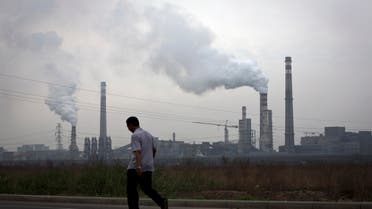 In this May 29, 2015 photo, a man walks past a coal-powered steel plant in Tianjin, China.  (AP)