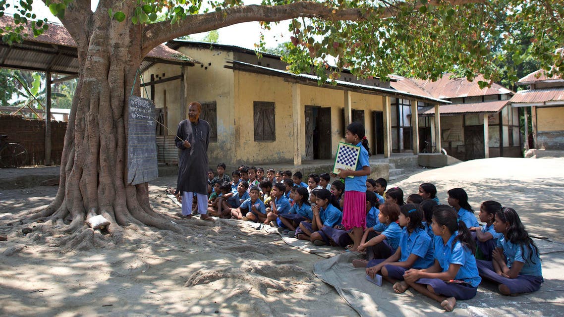 Indian school children attend a class under a tree outside a school in east Gagolmari village about 70 kilometers (44 miles) east of Gauhati, India, Thursday, April 9, 2015.AP
