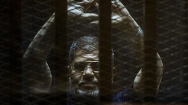 A file picture taken on June 2, 2015 shows ousted Egyptian president Mohamed Morsi gesturing from the defendants cage as he attends his trial at the police academy on the outskirts of the capital Cairo. AFP