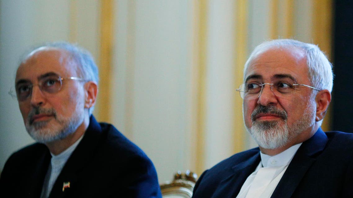 Iranian Foreign Minister Mohammad Javad Zarif and the Head of the Iranian Atomic Energy Organization Ali Akbar Salehi, left, meet with U.S. Secretary of State John Kerry in Vienna, Austria, Friday July 3, 2015. Iran has committed to implementing the IAEA's "additional protocol" for inspections and monitoring as part of an accord, but the rules don't guarantee international monitors can enter any facility including sensitive military sites, so making it difficult to investigate allegations of secret work on nuclear weapons. (Carlos Barria/Pool via AP)