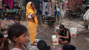  An Indian girl bathes beside a woman brushing her teeth at a shanty area in New Delhi, India, Tuesday, June 30, 2015. There is no direct supply of potable water at homes in most of the poor neighborhoods in the country and people have to depend on regulated supply of water from public taps erected on roadsides, with a single tap catering to hundreds of households. (AP Photo/Tsering Topgyal)