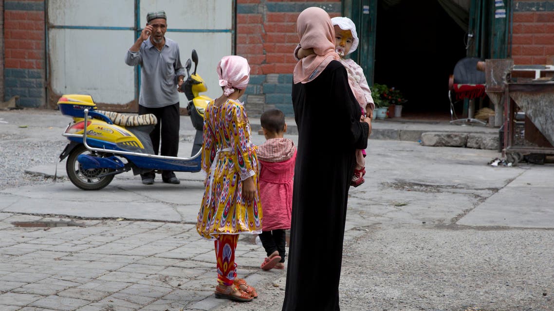 In this photo taken Thursday, July 17, 2014, a Uighur woman wears a full length garment and headscarf associated with conservative Islam in the city of Aksu in western China's Xinjiang province. AP