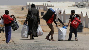 Image: Newly-arrived Syrian refugees carry their belongings as they walk at Azraq refugee camp near Al Azraq area, east of Amman, August 19, 2014. REUTERS/Muhammad Hamed