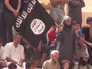 A man waves an ISIS flag as the crowd look on (Video grab)