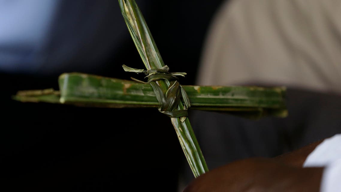 A Nigerian holds a cross made out of a palm leaf, during Palm Sunday mass at St Theresa's Catholic Church, in Yola, Nigeria. Sunday, March 29, 2015. (AP Photo/Sunday Alamba)