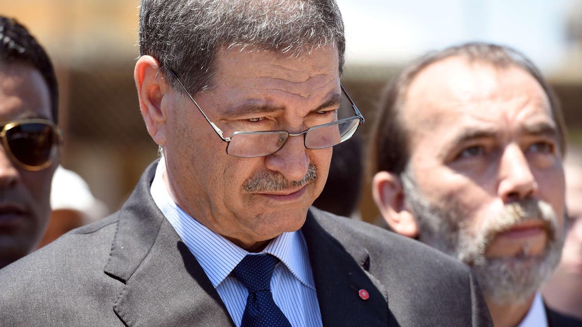 Tunisian Prime Minister Habib Essid observes a minute's silence on the beach in the Tunisian coastal city of Sousse on July 3, 2015. AFP