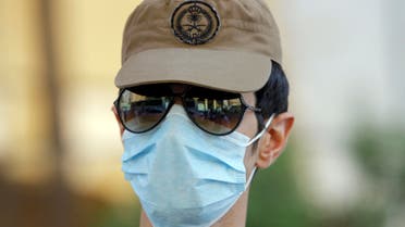 A Saudi policeman wears a medical mask as he watches pilgrims in the Muslim holy city of Mecca, Saudi Arabia, Sunday, Oct. 13, 2013. This year some pilgrims and security personnel are wearing masks as a precaution against the Middle East respiratory syndrome, which has stricken nearly 100 people, most of them in Saudi Arabia and the Middle East. The Saudi health minister, Abdullah al-Rabiah, said late Saturday that no cases of the coronavirus infection have been detected among pilgrims. (AP Photo/Amr Nabil)