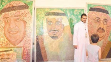 Hisham Abdu Rabbah Al-Najjar standing by his portraits at the heritage festival in Balad. — SG photo