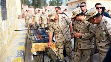 In this picture provided by the office of the Egyptian Presidency, Egyptian President Abdel-Fattah el-Sissi, second right, inspects weapons with members of the Egyptian armed forces in Northern Sinai, Egypt, Saturday, July 4, 2015. Egyptian President Abdel-Fattah el-Sissi has traveled to the troubled northern part of the Sinai Peninsula to inspect troops, after Islamic State-linked militants struck a deadly blow against the military this week in a coordinated assault. (Egyptian Presidency /Mohammed Abdel-Muati via AP)
