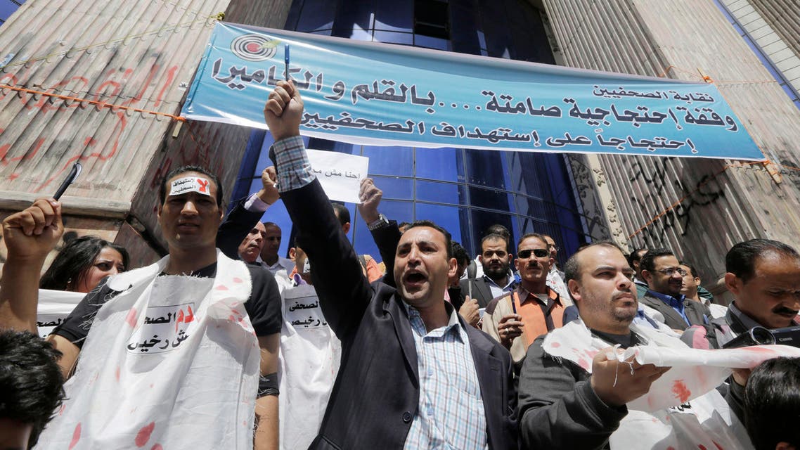 Egyptian journalists shout slogans as some wear symbolic white shrouds during a protest at the journalists syndicate in Cairo, Egypt, Thursday, April 17, 2014. AP