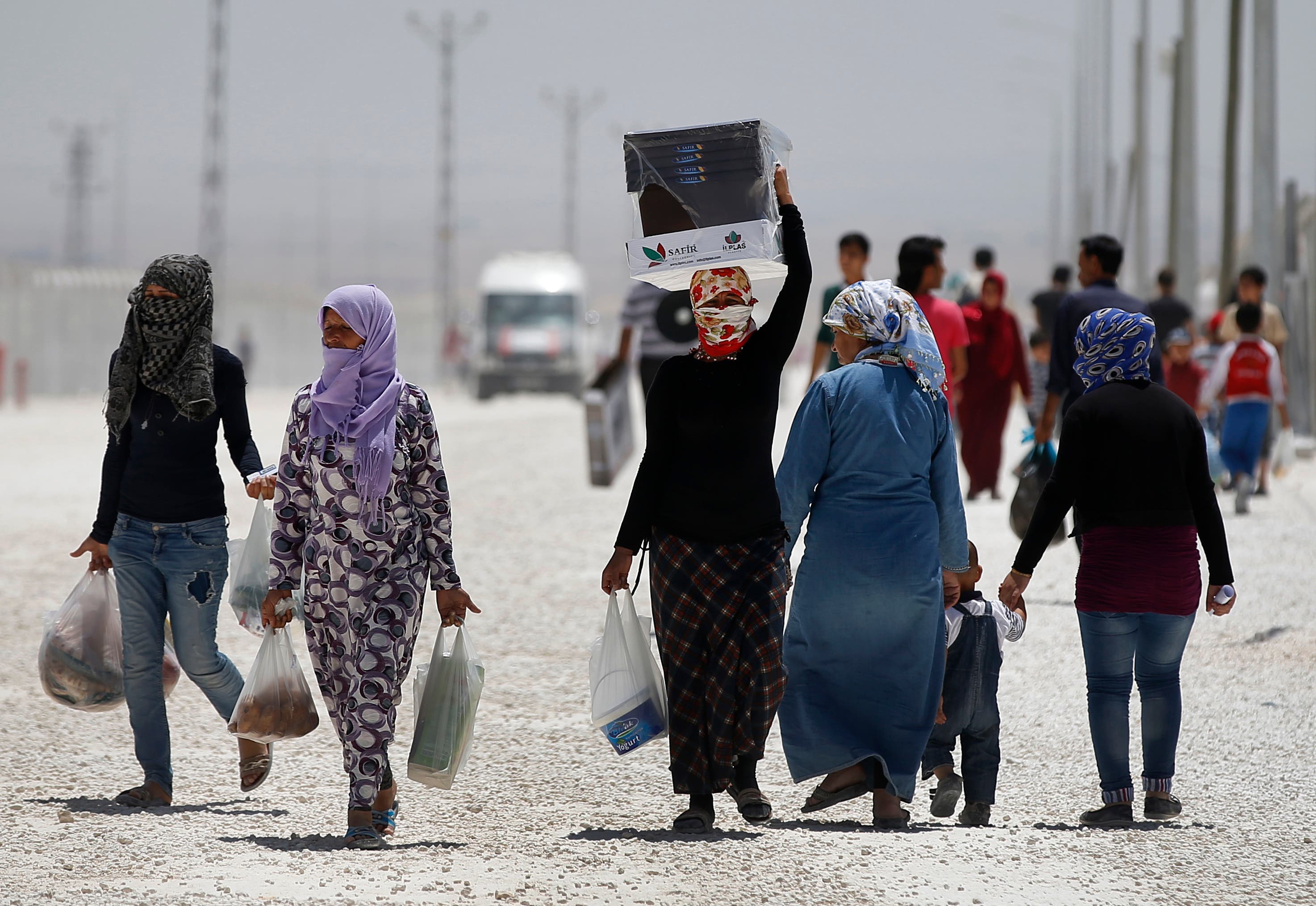 Syrian refugees walk at a refugee camp in Suruc, on the Turkey-Syria border, Friday, June 19, 2015. (AP)