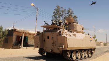 Egyptian Army soldiers patrol in an armored vehicle backed by a helicopter gunship during a sweep through villages in Sheikh Zuweyid, north Sinai, Egypt. AP