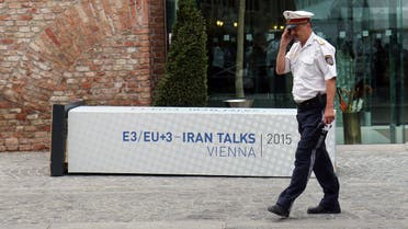 A Police officer walks past a fallen poster for the Iran talks in front of at Palais Coburg where closed-door nuclear talks with Iran take place in Vienna, Austria, Monday, July 6, 2015. (AP) 