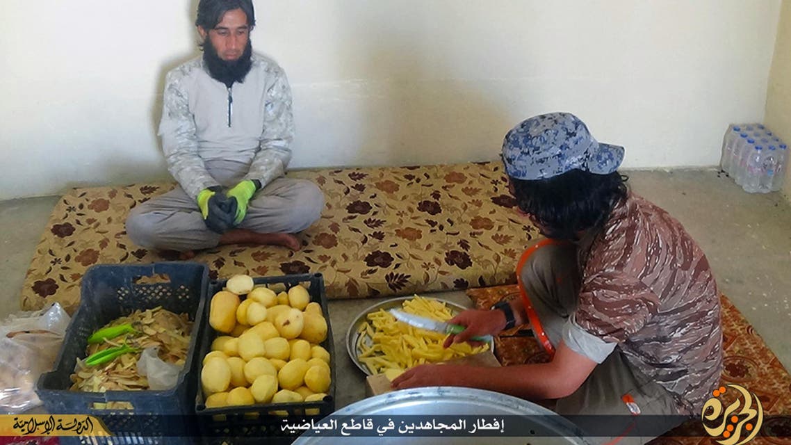 In this Sunday, June 28, 2015 photo provided by a website of the Islamic State group, IS members prepare meals, known as Iftar, for its members who fight on the front lines, in the northern Iraqi town of Ayadiyah, near Mosul. AP