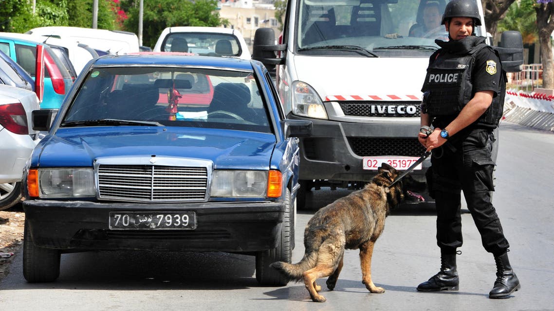 A police officer with his dog patrols near the scene of a shooting at the Bouchoucha barrack in Tunis, Tunisia, Monday May 25, 2015. A Tunisian soldier opened fire on fellow troops at a military barrack in the capital Monday, killing seven people and injuring ten, before he was himself killed, a spokesman for Tunisia's Defense Ministry said. (AP Photo/Ali Dali)