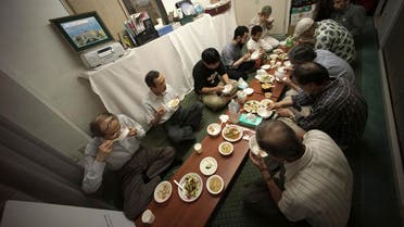 In this July 11, 2015, photo, Muslim men break their fast with chopsticks as they eat "Gyudon", or Japanese beef bowl, at the Japan Muslim Association in Tokyo. AP