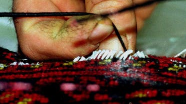 A Cypriot drug enforcement officer gently removes a thread from a hand made Persian carpet containing heroin in Nicosia Thursday, February 3, 2000. Three Persian rugs containing a total of four kilos of the drug were discovered Wednesday by Cypriot custom officers in Larnaca, Cyprus in the suitcase of 35-year old Iranian Fereiboon Batelani from Tehran who was traveling with his wife and five-year old son. (AP Photo/Philip Mark)