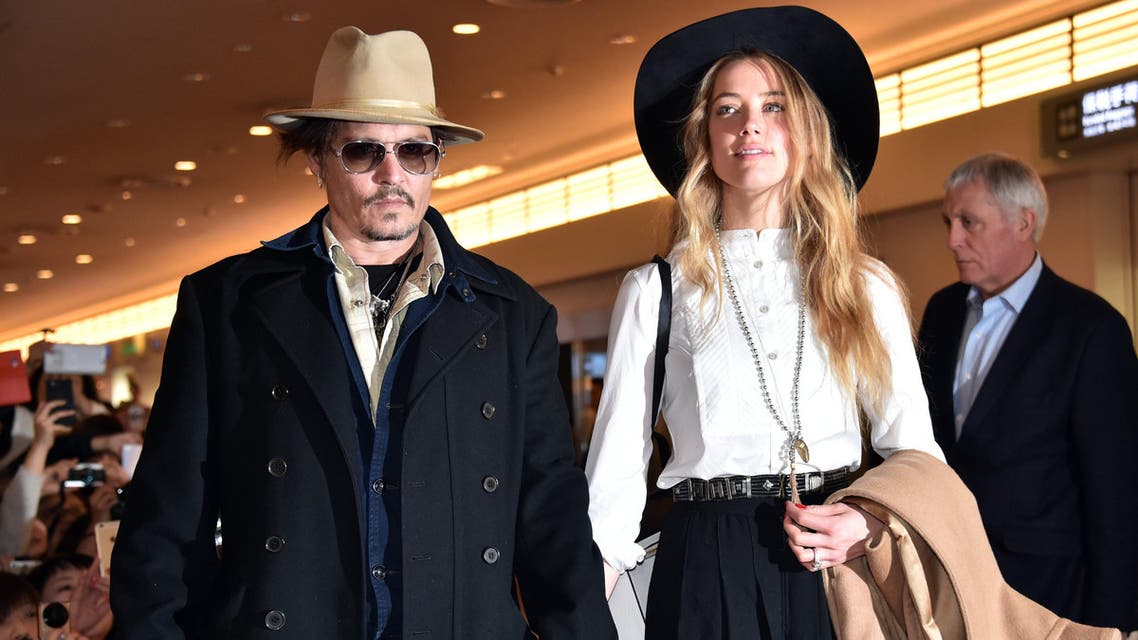 This file photo taken on January 26, 2015 shows US actor Johnny Depp (L) accompanied by his wife, US actress and model Amber Heard (R) after their arrival at Tokyo International Airport. Australia's "war on terrier" with Johnny Depp has taken another turn, with authorities saying on July 16 the Hollywood star's wife faces charges over bringing their two dogs into the country. AFP PHOTO / FILES / YOSHIKAZU TSUNO
