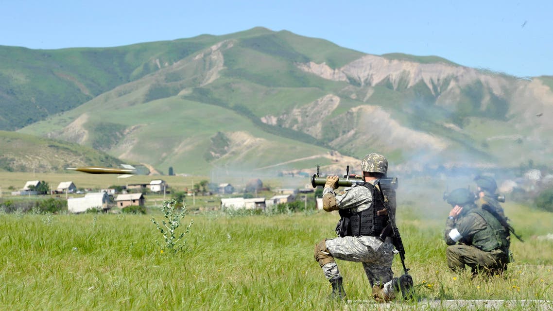 A Kyrgyz soldier fires a grenade from a grenade launcher, as Russian soldiers watch during joint Kyrgyz-Russian paratroopers exercise at the Ala-Too military base near Kyrgyz capital of Bishkek on Thursday, May 28, 2015. (AP)