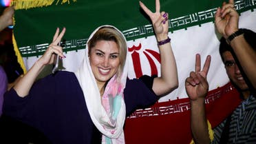 An Iranian woman shows the victory sign as people celebrate on a street following a landmark nuclear deal, in Tehran, Iran, Tuesday, July 14, 2015. Overcoming decades of hostility, Iran, the United States, and five other world powers struck a historic accord Tuesday to check Tehran's nuclear efforts short of building a bomb. The agreement could give Iran access to billions in frozen assets and oil revenue, stave off more U.S. military action in the Middle East and reshape the tumultuous region. (AP Photo/Ebrahim Noroozi)