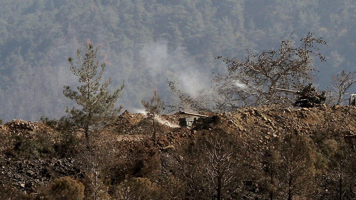 In this photo taken Thursday, March 27, 2014, Syrian government artillery forces fire towards rebels’ position during clashes in Misherfeh town in the province of Latakia, Syria.
