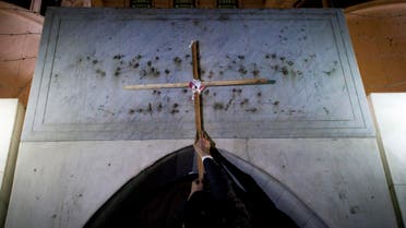 An Egyptian protester places a wooden cross at the entrance of the Libyan embassy AP