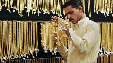 A salesperson arranges the gold chains at a jewelry store in Bangalore, India, Friday, March 14, 2008. Gold zoomed past all previous records to set at new peak of Rupees 13,200 or US$ 325 per ten grams on the bullion market Friday. (AP Photo/Aijaz Rahi)