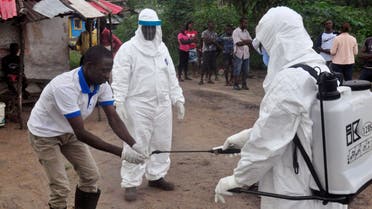 Health workers wash their hands after taking a blood specimen from a child to test for the Ebola virus in an area where a 17-year old boy died from the virus on the outskirts of Monrovia, Liberia, Tuesday, June 30, 2015. Liberian authorities on Tuesday quarantined the area where the corpse of the boy was found, sparking fears this West African country could face another outbreak of the disease nearly two months after being declared Ebola-free. (AP Photo/ Abbas Dulleh)
